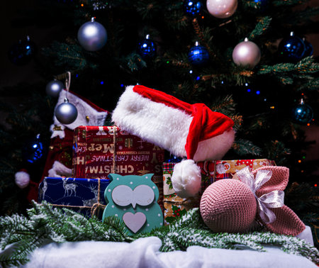 Christmas, New Year interior with red brick wall background, decorated fir tree with garlands and balls, dark drawer and deer figureの写真素材