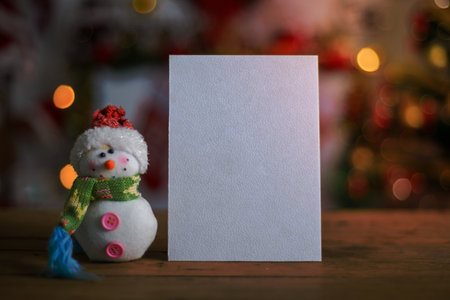 Blank Christmas card next to ornament on wooden table, Christmas background blurred. Christmas card mockup.の写真素材
