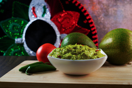 Guacamole served on a white plate on a wooden table. Guacamole ingredients.の写真素材