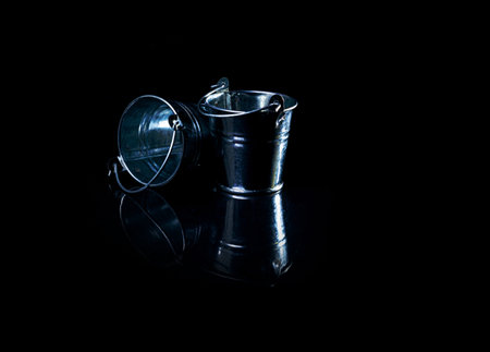 Many aluminum ice bucket laid in wait for use. many stainless multi-colored buckets with reflection, black background isolated,の写真素材