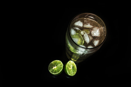 Glass of cold lemonade on black table. Ice cold drink on dark background.の写真素材