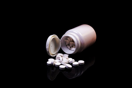 Top view mockup bottle for pills and vitamins on black background, natural organic bio supplement
Medical pills in white jar on an isolated black background with reflectionの写真素材