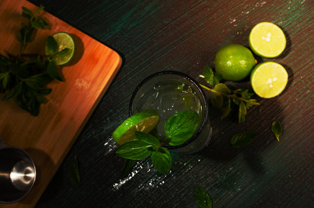 Mojito, typical cuban cocktail served in a crystal glass on a green table. Table decorated with cocktail ingredients.の写真素材