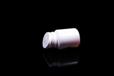 Top view mockup bottle for pills and vitamins on black background, natural organic bio supplement
Medical pills in white jar on an isolated black background with reflectionの写真素材