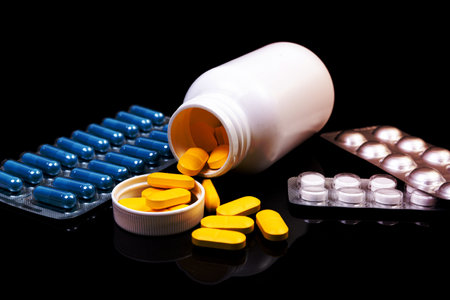 Top view mockup bottle for pills and vitamins on black background, natural organic bio supplement
Medical pills in white jar on an isolated black background with reflectionの写真素材