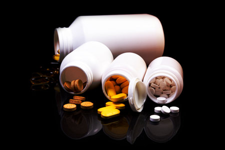 Top view mockup bottle for pills and vitamins on black background, natural organic bio supplement
Medical pills in white jar on an isolated black background with reflectionの写真素材