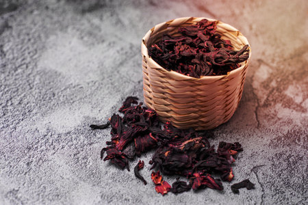 Jamaica flower in woven fiber basket on concrete table. Hibiscus flower ready to prepare beverage.の写真素材