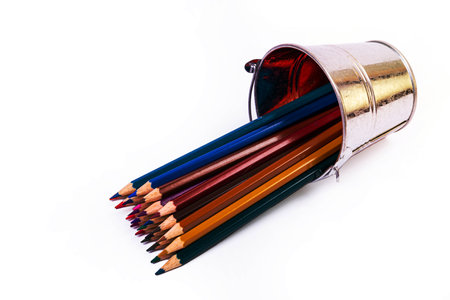 multi-colored pencils in a wine glass and a bucket. Selective blurred a group of coloring pencils in a wine glass on the isolated white or black background , Modern art. Modern designの写真素材