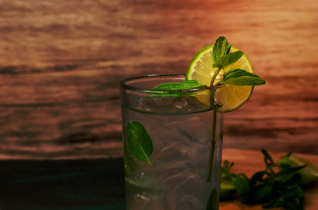 Mojito, typical cuban cocktail served in a crystal glass on a green table. Table decorated with cocktail ingredients.の写真素材