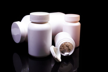 Top view mockup bottle for pills and vitamins on black background, natural organic bio supplement
Medical pills in white jar on an isolated black background with reflectionの写真素材