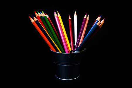 multi-colored pencils in a wine glass and a bucket. Selective blurred a group of coloring pencils in a wine glass on the isolated white or black background , Modern art. Modern designの写真素材