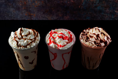 Milkshakes of different flavors on a dark background.の写真素材