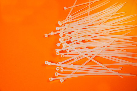 nylon cable ties in glass in jar in bucket on orange background front top view isolatedの写真素材