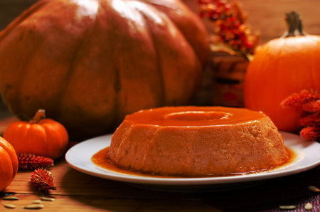 Pumpkin flan, dessert made for the Day of the Dead. Dessert on wooden table with autumn decoration around.の写真素材