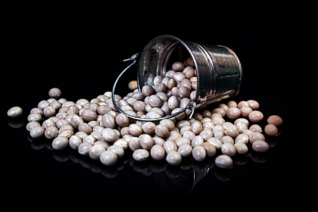raw white beans in glass jar, wine glass. in bucket. raw white beans on black background. front view raw white beans, dropped from hand, isolated on blackの写真素材