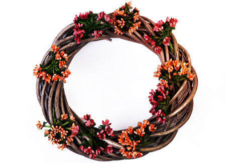 Wreath woven from the branches of the vine isolated red white blue pink brown vine wreath with flowers fruits rowanの写真素材