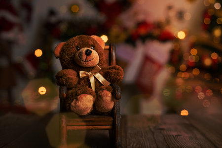 Teddy bear on wooden table with blurred Christmas background .の写真素材
