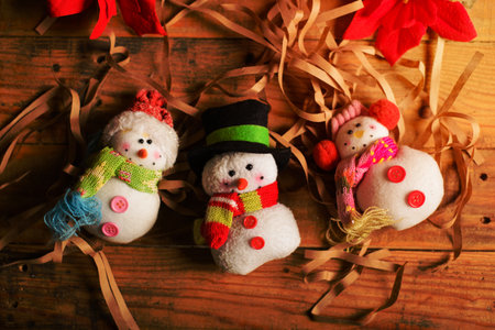 Snowmen made of wool and yarn on wooden table. Decorative crafts for Christmas.の写真素材