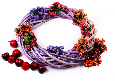 Wreath woven from the branches of the vine isolated red white blue pink brown vine wreath with flowers fruits rowanの写真素材