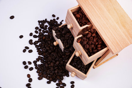 Wooden box with cells filled with coffee beans. Coffee beans scattered side by side Isolated on white background Top viewの写真素材