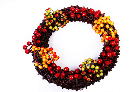 Wreath woven from the branches of the vine isolated red white blue pink brown vine wreath with flowers fruits rowanの写真素材