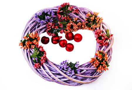 Wreath woven from the branches of the vine isolated red white blue pink brown vine wreath with flowers fruits rowanの写真素材