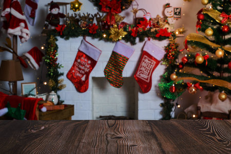 Wooden table in foreground and room with Christmas decorations in background. Selective focus, blurred background.の写真素材