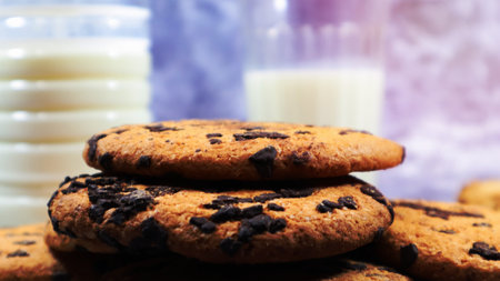 American chocolate chip cookies stacked on top of each other with milk in a glass on a gray background. Traditional rounded crunchy dough with chocolate chips. Bakery. Delicious dessert, pastriesの写真素材