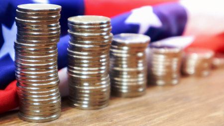 American coins with the flag of the United States of America. Investment concept, business finance and money saving. US coins stacked against the background of the American flag. Selective focusの写真素材