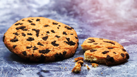 One soft, freshly baked chocolate chip cookie on a gray marble kitchen countertop. American traditional dessert. Delicious sweet food. Homemade baking concept for the holiday. Culinary background.の写真素材