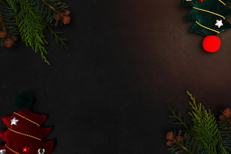 Christmas or New Year dark background with fir branches, Xmas black board framed with season decorations, space for text, view from above.の写真素材