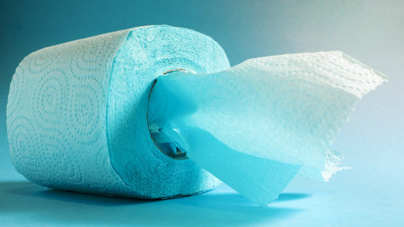 Blue roll of modern toilet paper on a blue background. A paper product on a cardboard sleeve, used for sanitary purposes from cellulose with cutouts for easy tearing. Embossed drawing.の写真素材