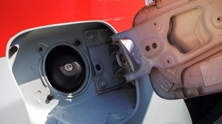 Fuel cap of a white sports car. Close the gas tank cap. The fuel tank is open. The fuel filler door is open and the fuel filler flap is closed. The exterior of the car with the filler door openの写真素材