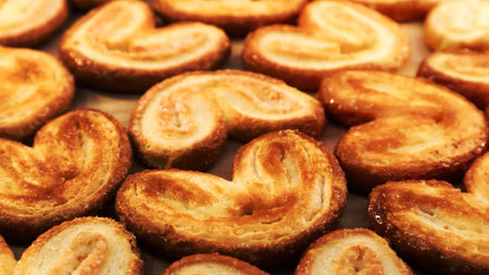 Fresh puff pastry palm cookies in the shape of a heart. Classic French pastries. Pig ear, elephant ear cookies, French hearts. View from above.の写真素材