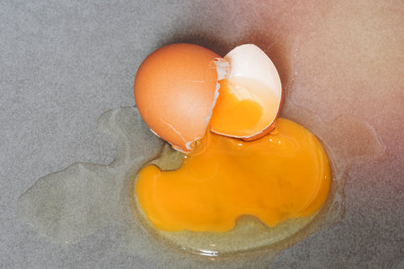 Egg drop crack splattered down on ceramic tile. Abstract macro with shallow and depth of field effectの写真素材
