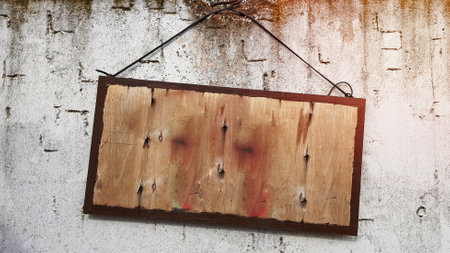 hanging wooden sign on a gray concrete wall. frame on a cement wall. A large wooden sign hanging on a rope with a concrete wall. Copy spaceの写真素材