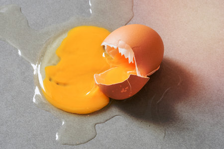 Egg drop crack splattered down on ceramic tile. Abstract macro with shallow and depth of field effectの写真素材