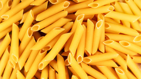 Penne Rigate Raw Pasta is a short pasta with oblique cuts and a ribbed surface. Traditional Italian pasta. Pasta background. Italian food ingredient top viewの写真素材