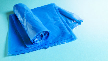 One roll of plastic garbage bags in blue on a blue background. Bags that are designed to accommodate garbage in them and used at home and placed in various garbage containersの写真素材