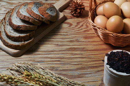 bread loaf and wheat ears and sack on wooden background.の写真素材