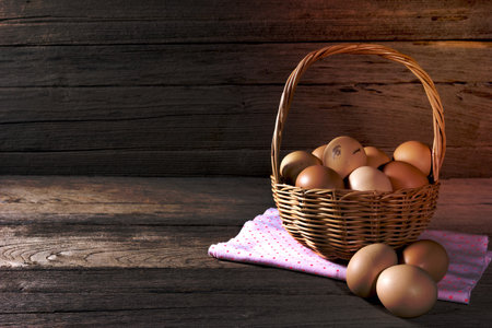 eggs in a wicker basket on wooden tableの写真素材