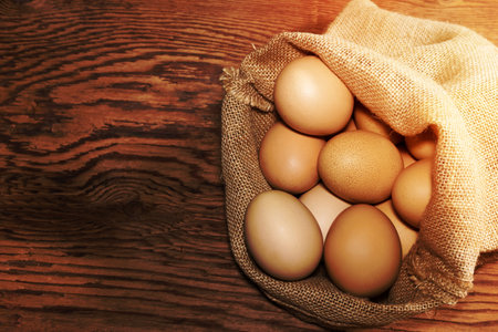 eggs in sackcloth bag on wooden tableの写真素材