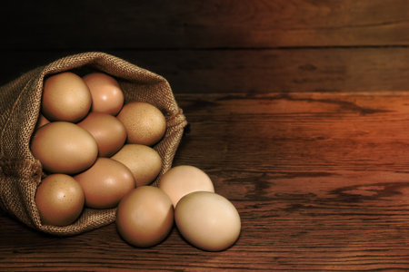 eggs in sackcloth bag on wooden tableの写真素材