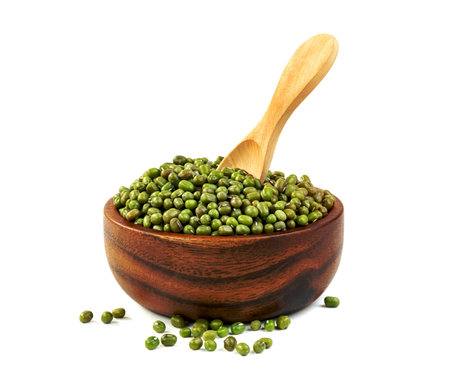 green mung beans with bowl and wooden spoon isolated on white backgroundの写真素材