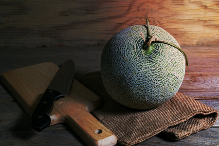melon and knife on cutting boardの写真素材