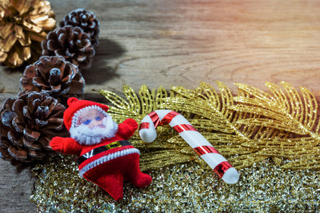Santa Claus doll with walking stick and pine cones for merry christmasの写真素材