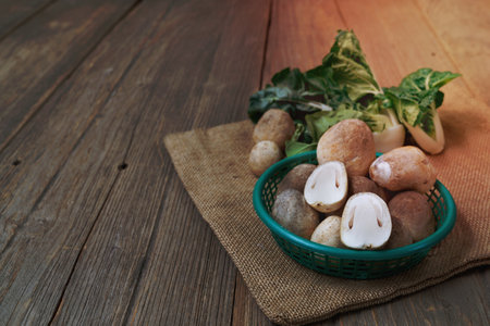 king oyster mushrooms and pak choi in plastic basket on wooden tableの写真素材