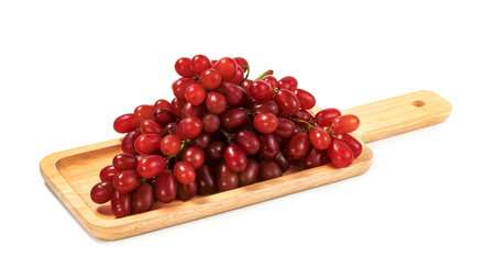 Closeup red seedless grapes with wooden tray isolated on white backgroundの写真素材