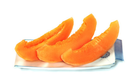 Orange cantaloupe melon fruit sliced on dish isolated on white backgroundの写真素材