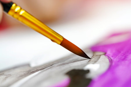closeup hands holding brush with watercolor paints by artist paintingの写真素材
